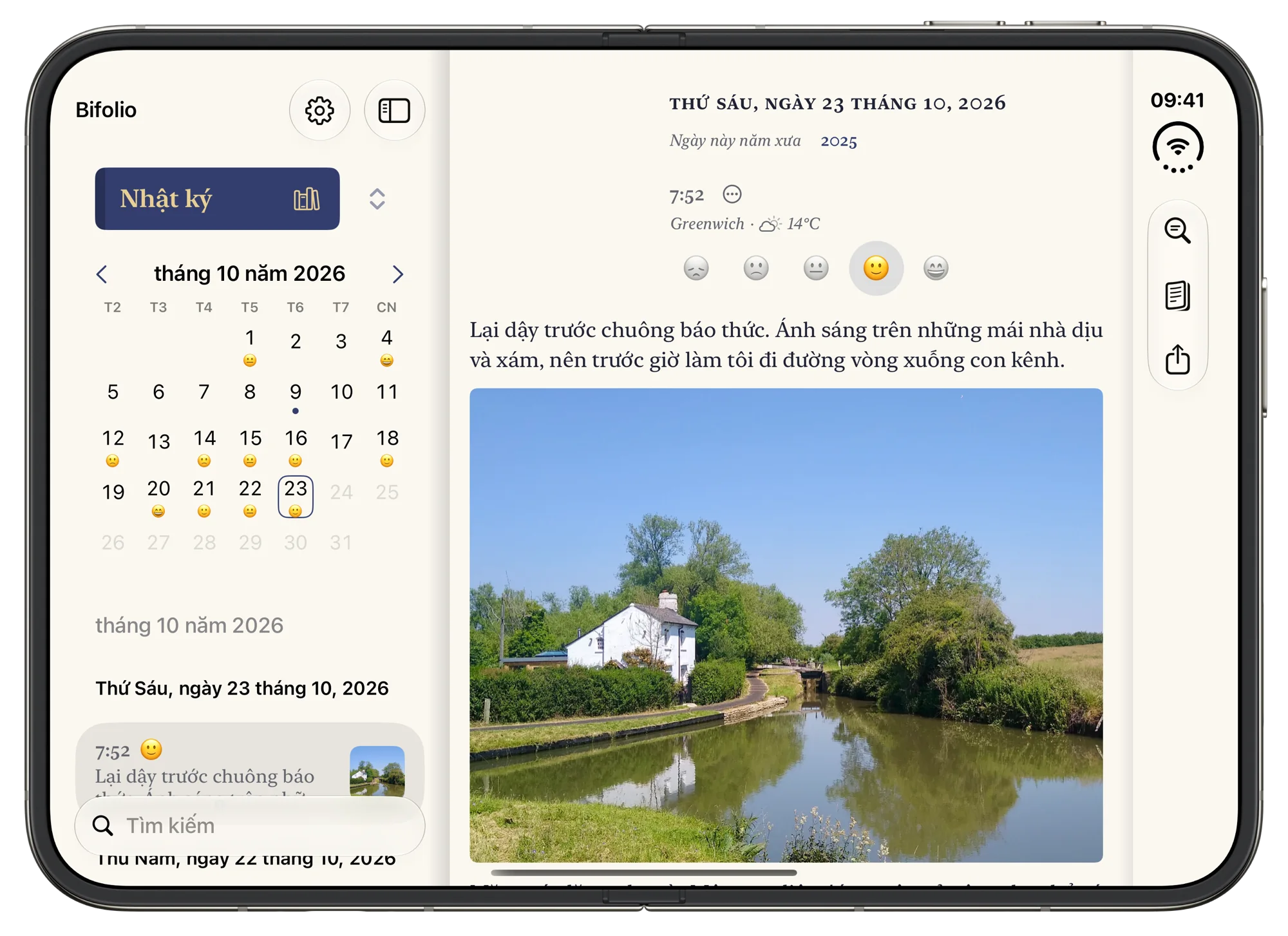 Bifolio mở trên iPhone Duo: lịch của tháng và các mục trong ngày ở nửa bên trái, thứ Sáu, 23 tháng 10 ở bên phải, kèm bức ảnh ngôi nhà của người gác âu thuyền bên một con kênh.